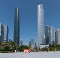 the skyscrapers are tall and have many buildings in them as well as there are green bushes