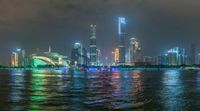 a city street with buildings and neon lights at night time in hong china as seen from an empty city highway