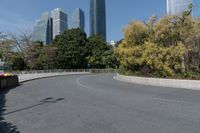 the curved road is in front of some high buildings in a city area with no people