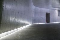 a light is glowing under a large concrete structure with lights on the side of it