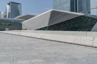 a large building with a very big white structure that looks like a pyramid on the top of a hill