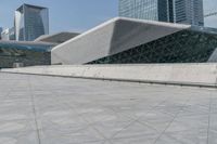 a large building with a very big white structure that looks like a pyramid on the top of a hill