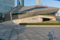 a stone building has a modern style architecture in it's centerpiece, as seen from the plaza