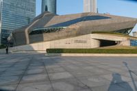 a stone building has a modern style architecture in it's centerpiece, as seen from the plaza