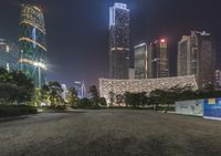 a black car is parked on a street near some tall buildings at night time a street light that looks like a statue