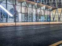 an outside bus station is illuminated at night time with rain falling down the walkway and lights shining on the outside