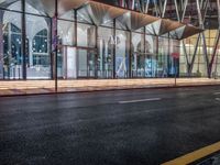 an outside bus station is illuminated at night time with rain falling down the walkway and lights shining on the outside