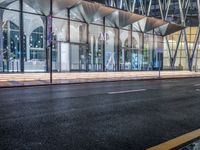 an outside bus station is illuminated at night time with rain falling down the walkway and lights shining on the outside