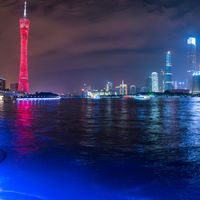 a city street with buildings and neon lights at night time in hong china as seen from an empty city highway