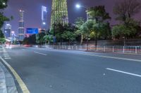 a city street with buildings and neon lights at night time in hong china as seen from an empty city highway