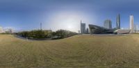 360 lens view of an urban area and skyline as seen from the edge of a green field