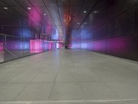 the floor of an underground tunnel is filled with lights and a metal railing that stretches right into the ground