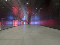 the floor of an underground tunnel is filled with lights and a metal railing that stretches right into the ground