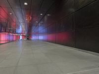 the floor of an underground tunnel is filled with lights and a metal railing that stretches right into the ground