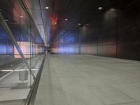 the floor of an underground tunnel is filled with lights and a metal railing that stretches right into the ground