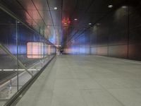 the floor of an underground tunnel is filled with lights and a metal railing that stretches right into the ground