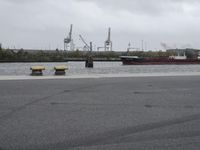 a river next to a parking lot and a boat on it's side in a body of water