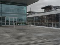 a building with a long fence around it that is near two tall windows and a large glass structure