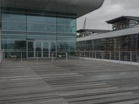 a building with a long fence around it that is near two tall windows and a large glass structure