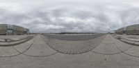 an fisheye lens view of a paved parking lot on a cloudy day of the 20th