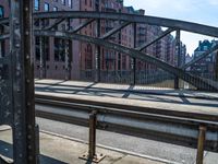 a train track next to an urban area with some buildings in the background and a bridge in between