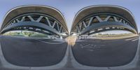 an upside down view of a curved bridge in the daytime time as people watch from inside it