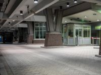 an empty parking garage with lots of windows on one side and floor tiles on the other