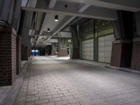 an empty parking garage with lots of windows on one side and floor tiles on the other