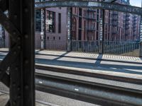 a train traveling down tracks near a building on the side of the road and next to it is a rail track