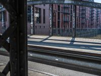 a train traveling down tracks near a building on the side of the road and next to it is a rail track