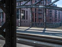 a train traveling down tracks near a building on the side of the road and next to it is a rail track