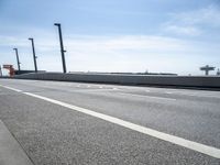 a car driving on a road through the airport in the sun with an airplane in the sky