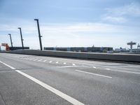 a car driving on a road through the airport in the sun with an airplane in the sky