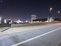 a city street with a bridge that has some cars on it at night time with streetlights