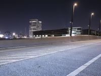 a city street with a bridge that has some cars on it at night time with streetlights