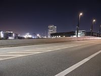 a city street with a bridge that has some cars on it at night time with streetlights