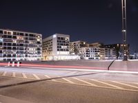 a city street with a bridge that has some cars on it at night time with streetlights
