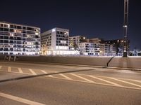 a city street with a bridge that has some cars on it at night time with streetlights