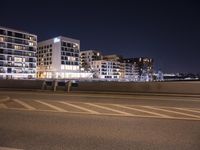 a city street with a bridge that has some cars on it at night time with streetlights