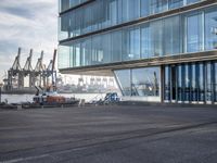 an airport parking lot with a plane parked outside the terminal building of it and a boat out in the harbor