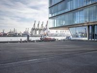 an airport parking lot with a plane parked outside the terminal building of it and a boat out in the harbor