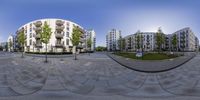 the 360 - eye image shows an intersection in a city plaza in front of an apartment complex