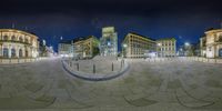 panorama of a square in the middle of a city at night with buildings surrounding it