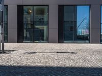 a view of the sidewalk and the entrance to the building with the reflection of another