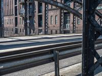 a train crossing over a bridge on a railway track with a building behind it in the background