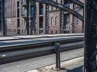 a train crossing over a bridge on a railway track with a building behind it in the background