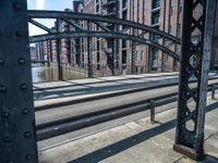 view looking into an open gate on the street, near several buildings and railroad tracks