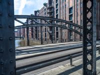 view looking into an open gate on the street, near several buildings and railroad tracks