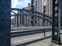 view looking into an open gate on the street, near several buildings and railroad tracks