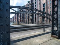 view looking into an open gate on the street, near several buildings and railroad tracks